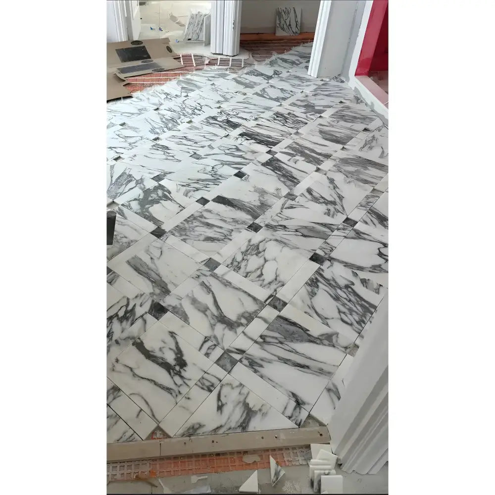 Arabescato Corchia Elite 12X24 Marble Tile with white gray veined pattern and dark accent tiles
