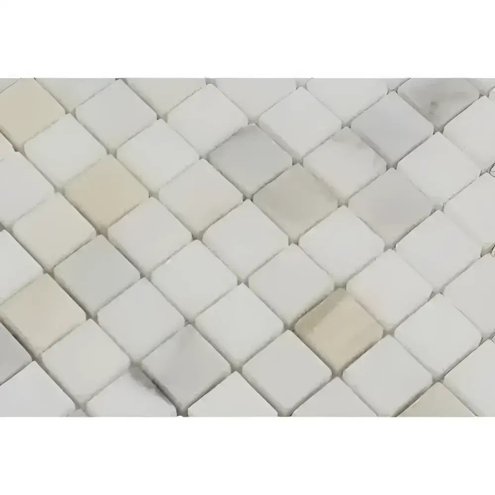 Diamond-patterned mosaic tile in Calacatta Gold Select Gold marble finish