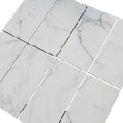 White marble tile arrangement of Calacatta Gold Select Gold 1X2 Brick Split-Faced Mosaic Marble Tile