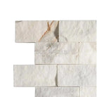Stacked white marble tiles from Calacatta Gold Select 2X4 Brick Split-Faced Mosaic