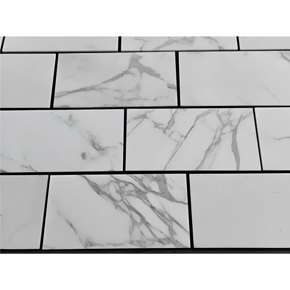 White marble-patterned tiles with dark grout from Calacatta Gold Select 12x24 collection