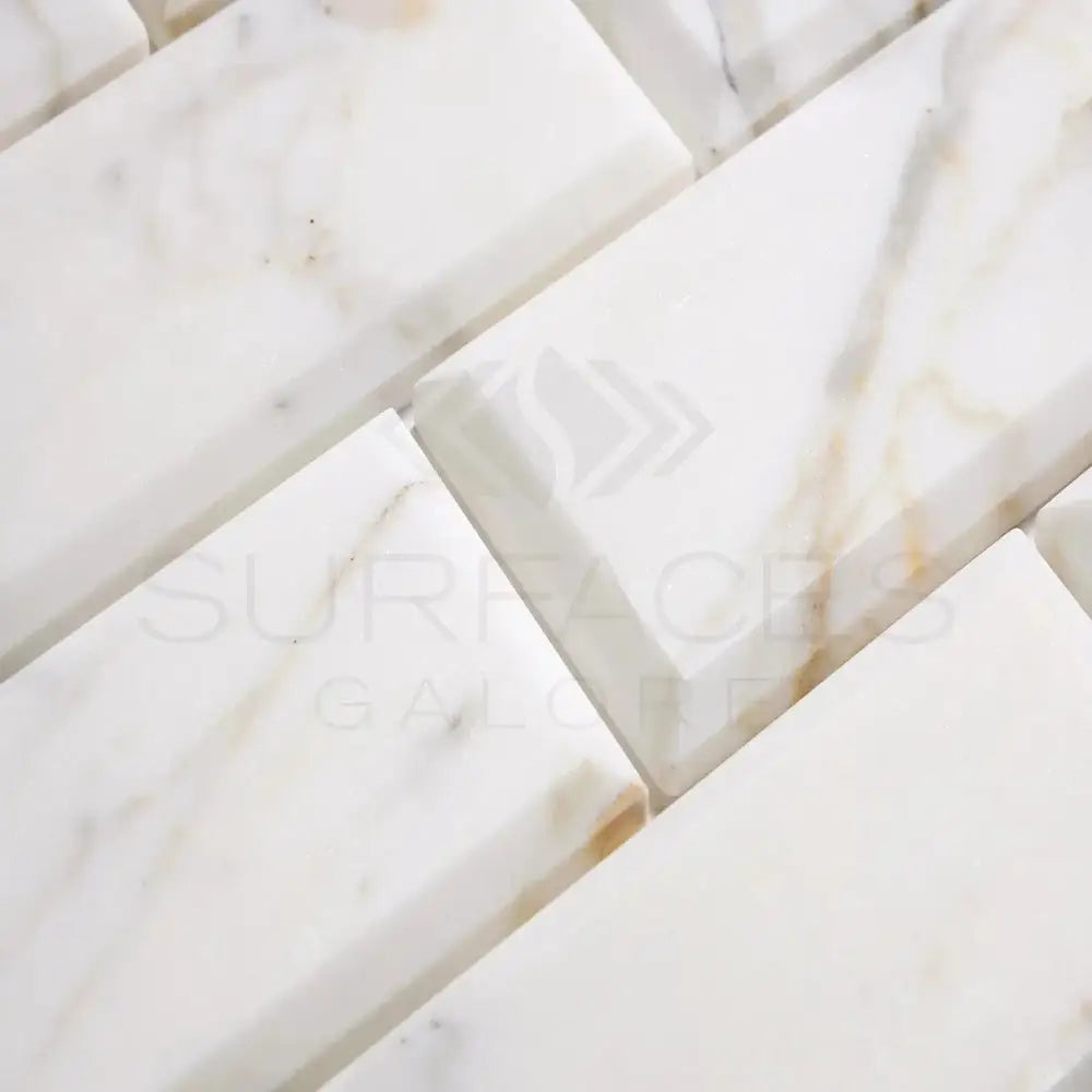 White marble brick tiles from Calacatta Gold Select in 3x6 deep-beveled polished-honed finish