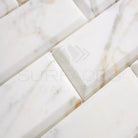 White marble brick tiles from Calacatta Gold Select in 3x6 deep-beveled polished-honed finish