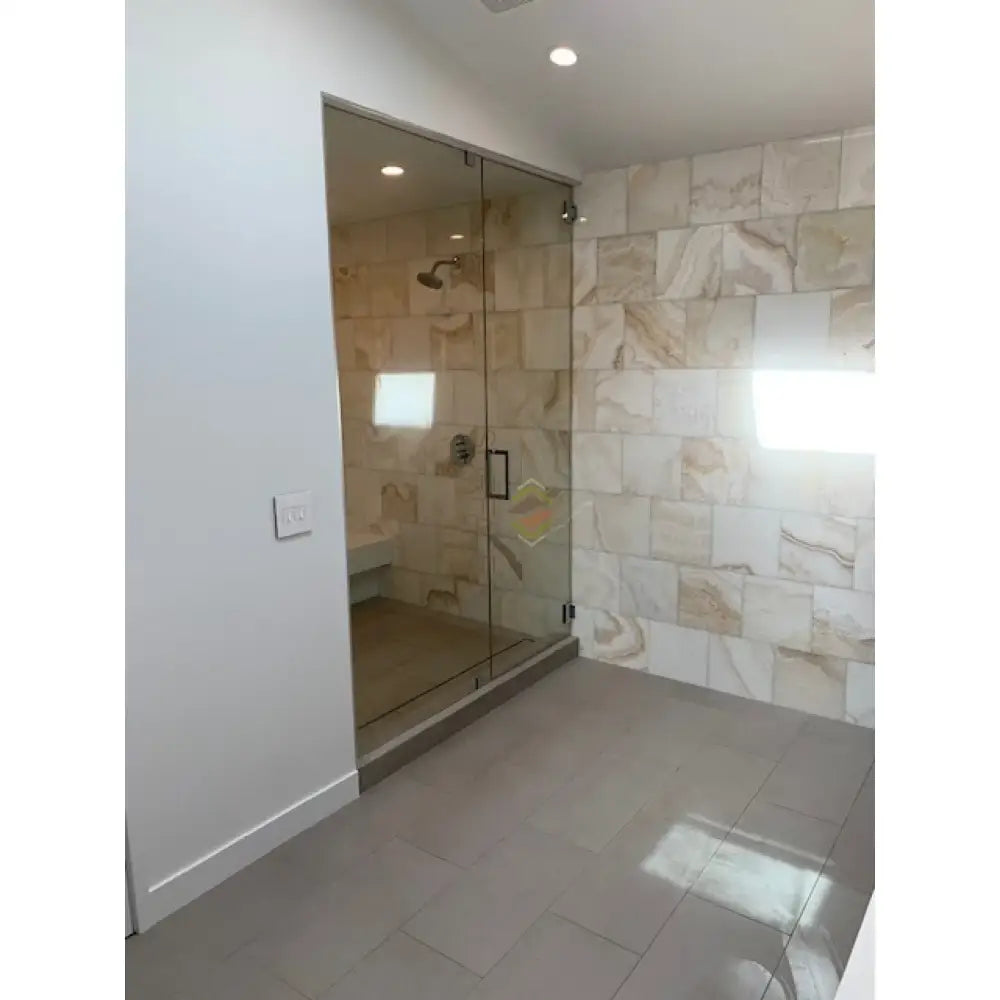 Glass-enclosed shower with Calacatta Gold Select Gold Marble 4X12 tile on tiled walls