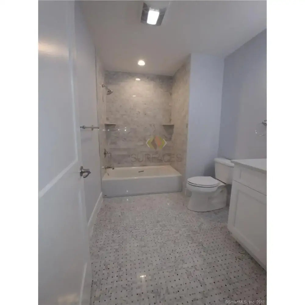 Bathroom with white fixtures featuring Carrara White Royale Marble 3x6 Tumbled tiles