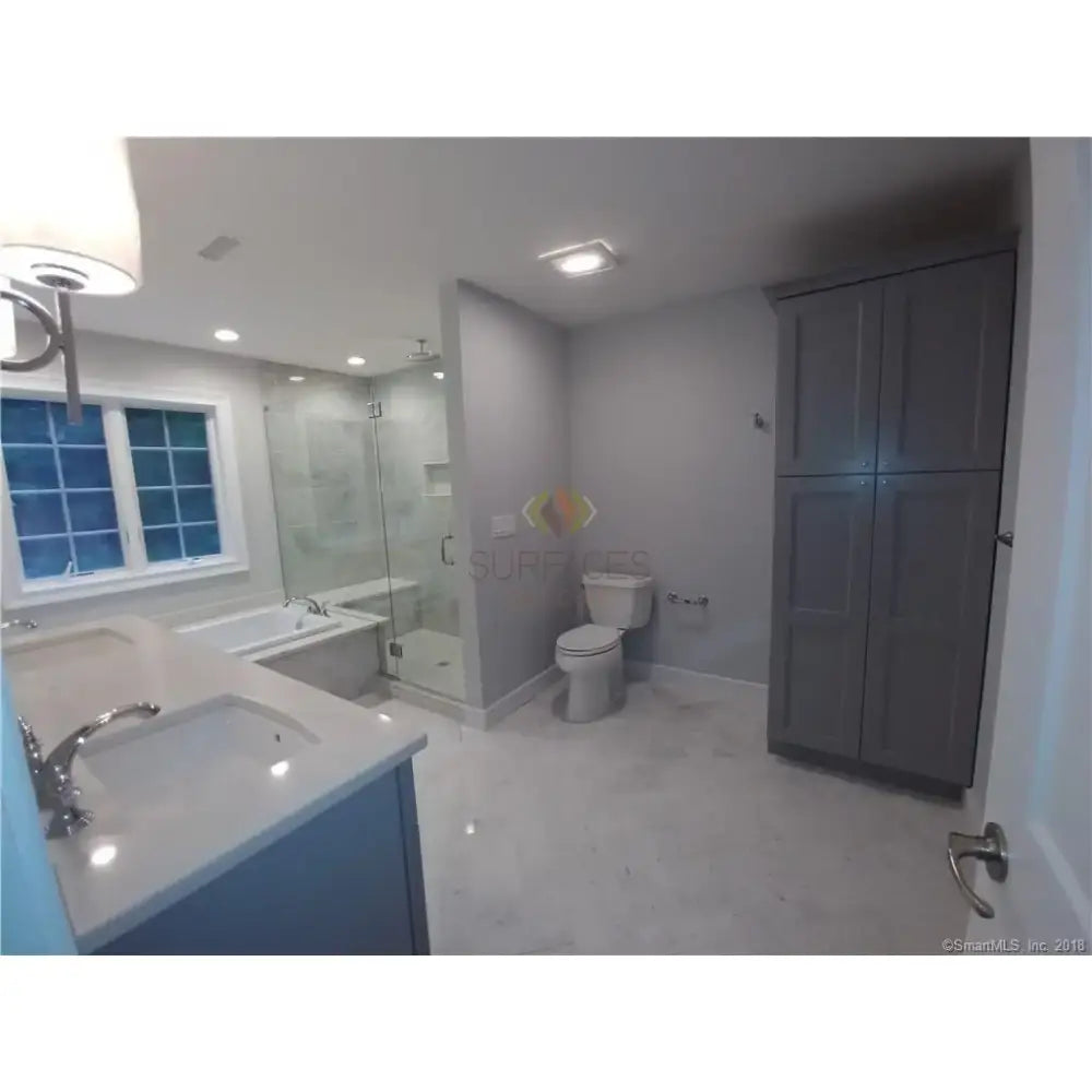 Bathroom with Gray Cabinets featuring Carrara White Royale Marble 3x6 Tumbled tiles