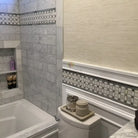 Bathroom interior featuring Carrara White Royale Marble 3x6 Tumbled tiles and decorative marble accents