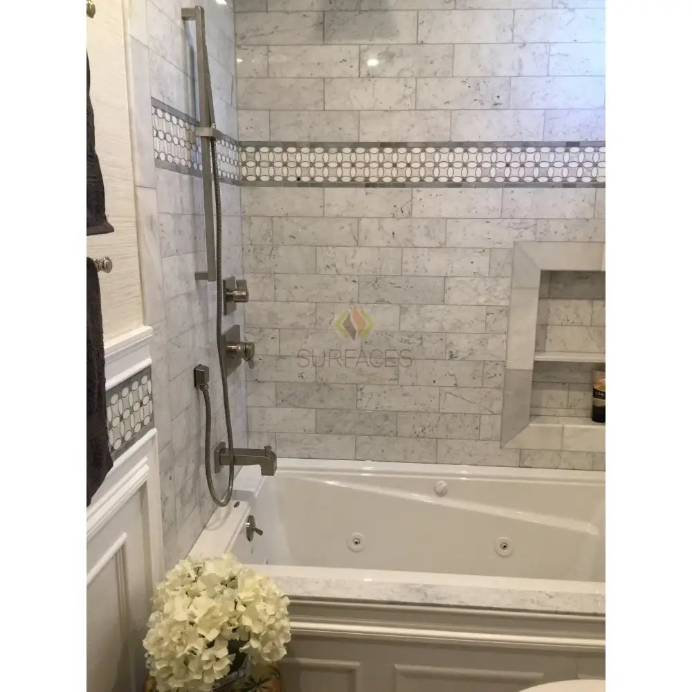 Elegant marble-tiled bathroom with Jacuzzi tub featuring Carrara White Royale Marble 3x6 Tumbled