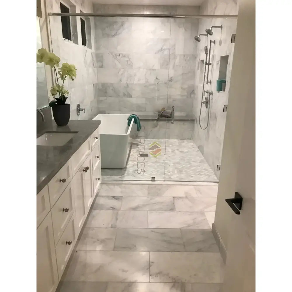 Modern marble bathroom featuring Carrara White Royale Marble 3X6 Tumbled tiles