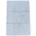 Three Carrara White Royale marble tiles in 3x6 tumbled finish for elegant flooring