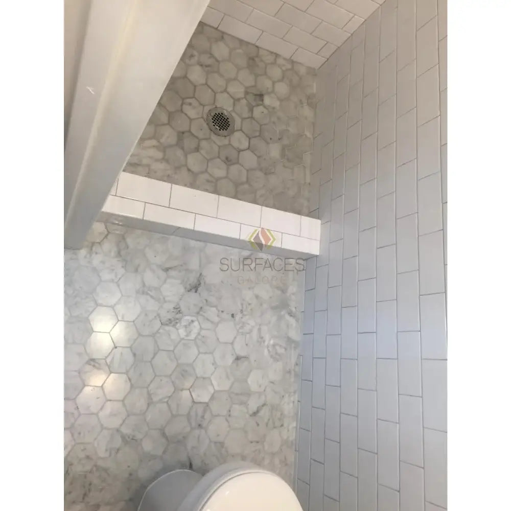 Tiled bathroom interior featuring Carrara White Royale Marble 3x6 Tumbled tiles