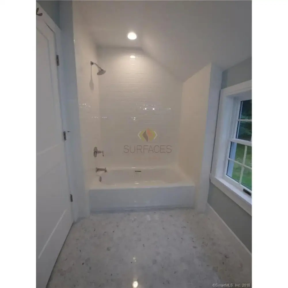 White tiled bathtub with Carrara White Royale Marble 3x6 tumbled tiles