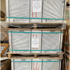 Pallet stacks of Bianco Carrara C marble tiles.