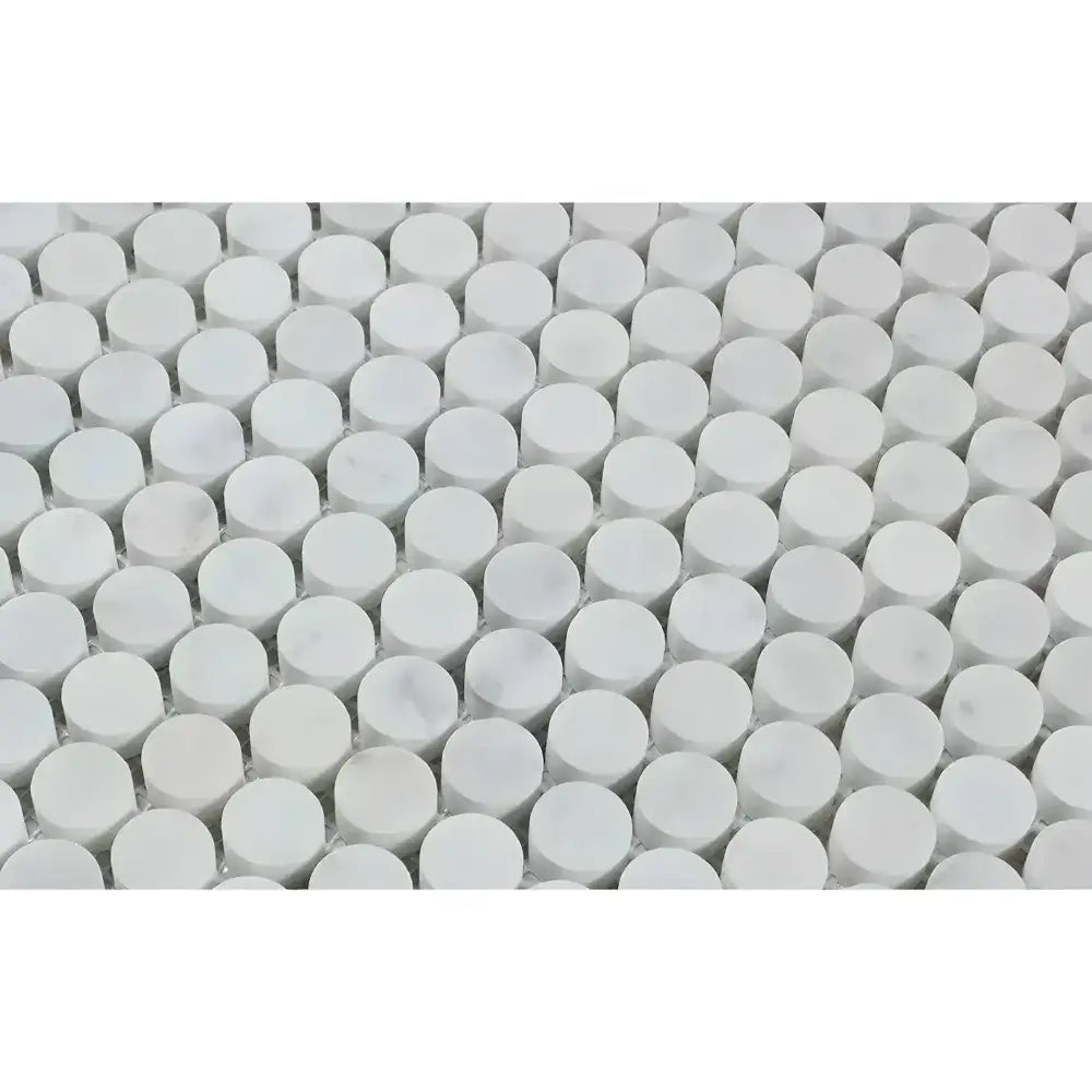 Repeating pattern of white unglazed cylindrical Carrara White Royale Penny-Round Mosaic Marble Tiles