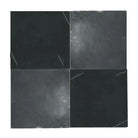 Four dark Nero Marquina and Arabescato Corchia marble square tiles in a 12x12 set