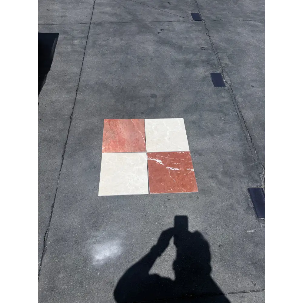 Four 12x12 marble tiles in red-toned Rojo Alicante and cream-colored Crema Marfil