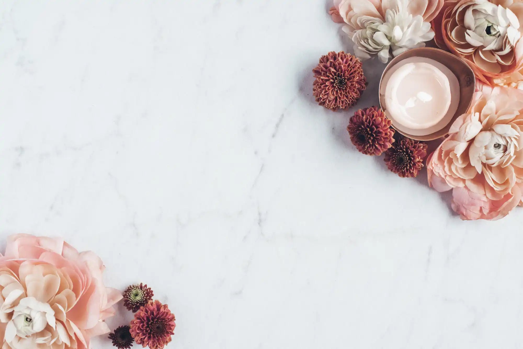 A collection of skincare products and flowers, including a jar of cream and various pink and burgundy blooms.