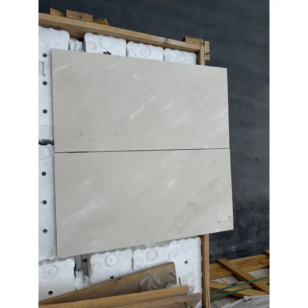 Two rectangular light-colored Crema Marfil Select Marble tiles for flooring or wall use