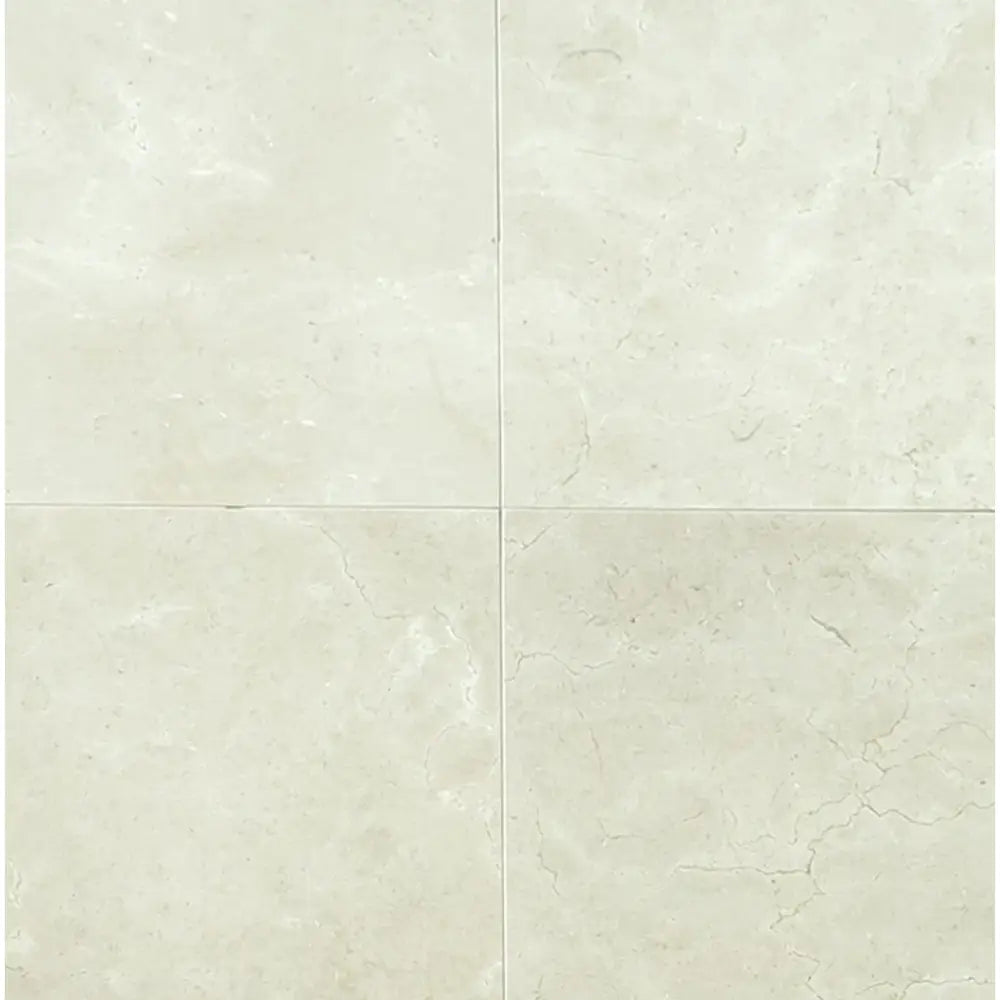 Four light-colored Crema Marfil Select Marble tiles in mini-brick mosaic pattern