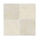 Four square Crema Marfil Select Marble 6X6 Tumbled coasters on a white background