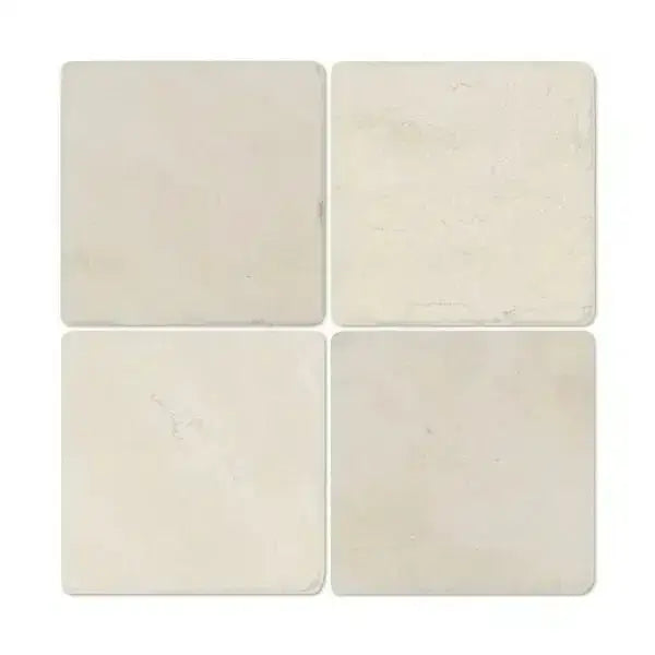 Four square Crema Marfil Select Marble 6X6 Tumbled coasters on a white background