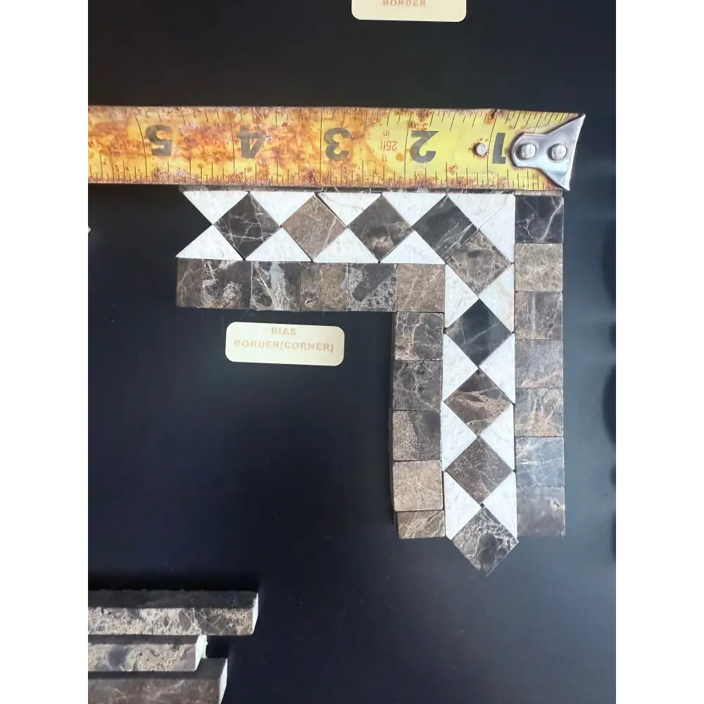 Mosaic tile corner with tape measure for Emperador Dark Oro Marble border with Crema Marfil dots