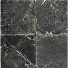 Four dark Nero Marquina Black Marble 4X4 Tumbled tiles showcasing elegant design
