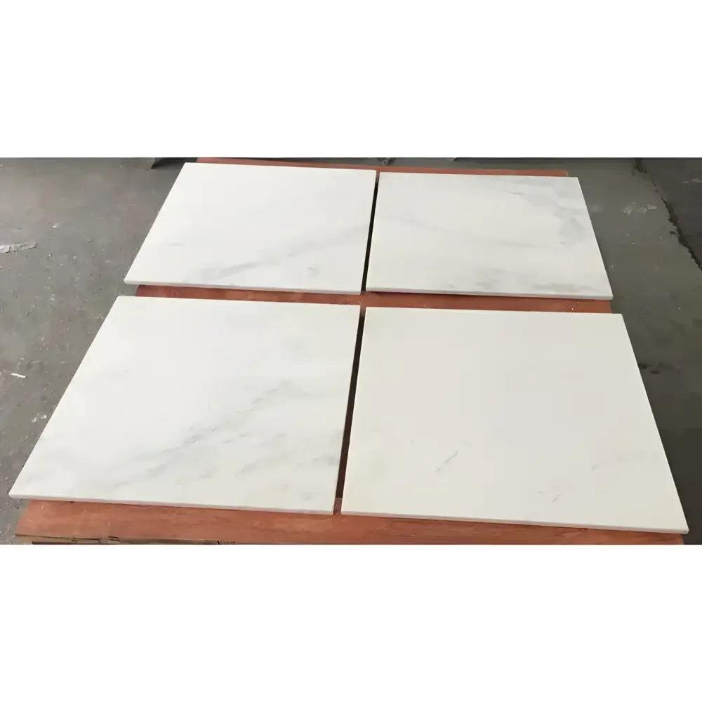 Four polished and honed Oriental White Aurora white marble tiles displayed