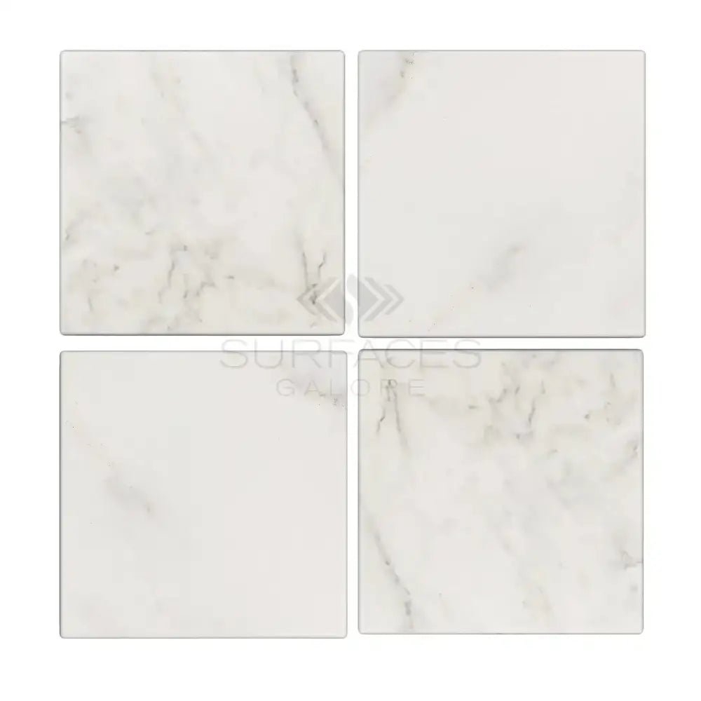 Four square Oriental White Aurora marble tiles in a product display