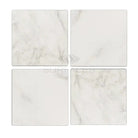 Four square Oriental White Aurora marble tiles in a product display