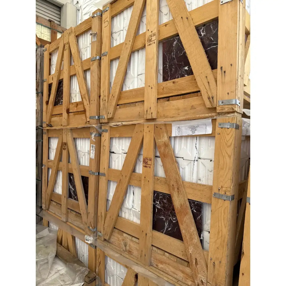 Stacked wooden crates filled with Rosso Levanto Marble 12X12 Polished tiles