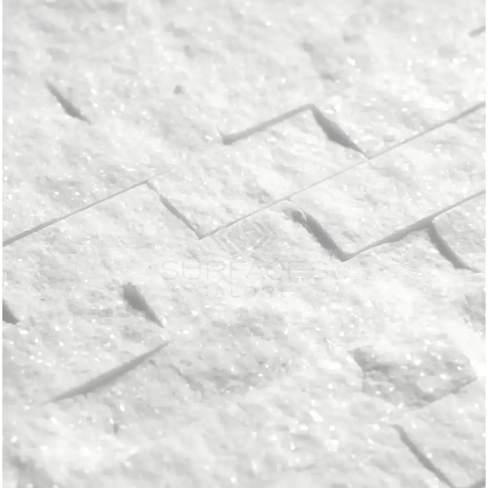 White textured stone wall featuring Thassos Supreme 1x2 Brick Mosaic Marble Split-Faced