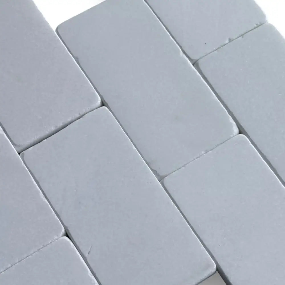 Gray rectangular Thassos Supreme 3x6 Marble Tumbled tiles in herringbone pattern