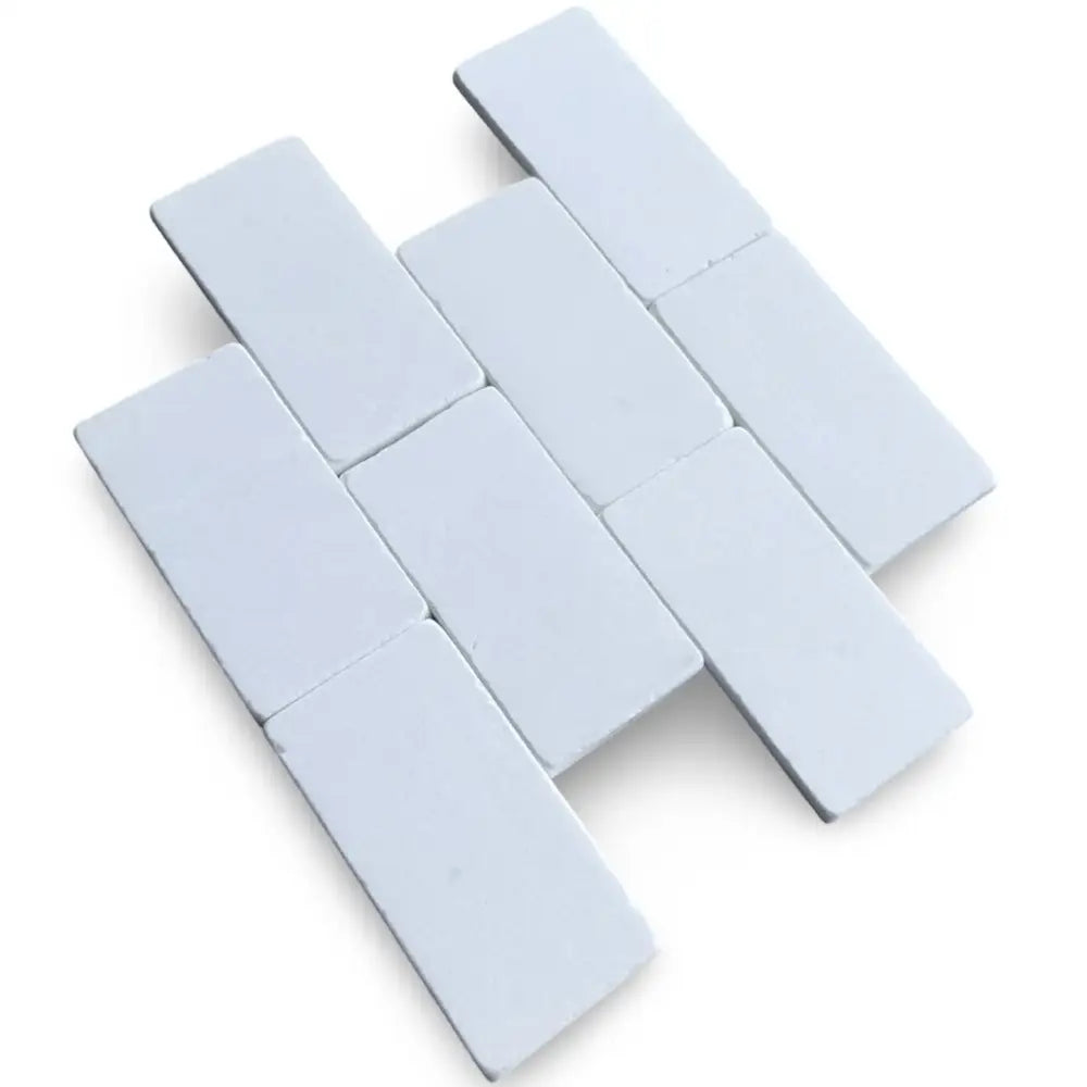 White rectangular tiles in herringbone pattern from Thassos Supreme 3X6 Marble Tumbled