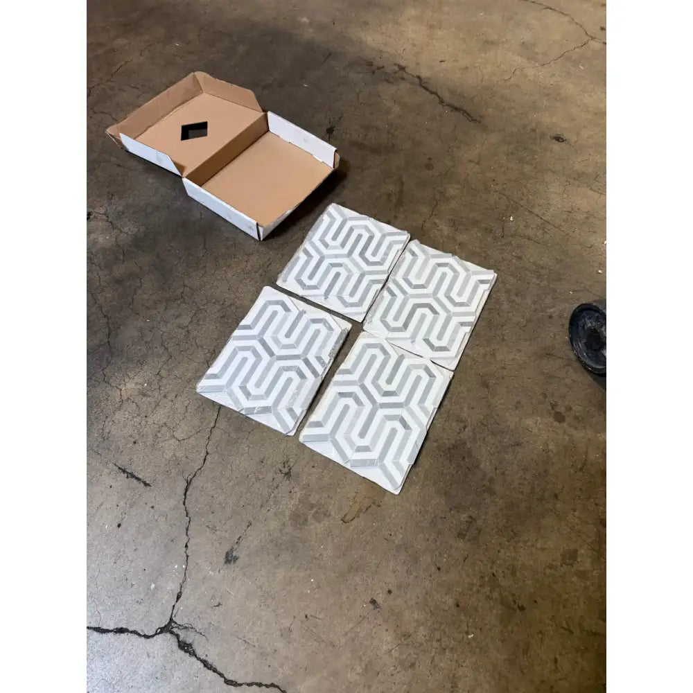 Geometric patterned tiles with a cardboard box for Thassos Supreme Berlinetta Mosaic Marble